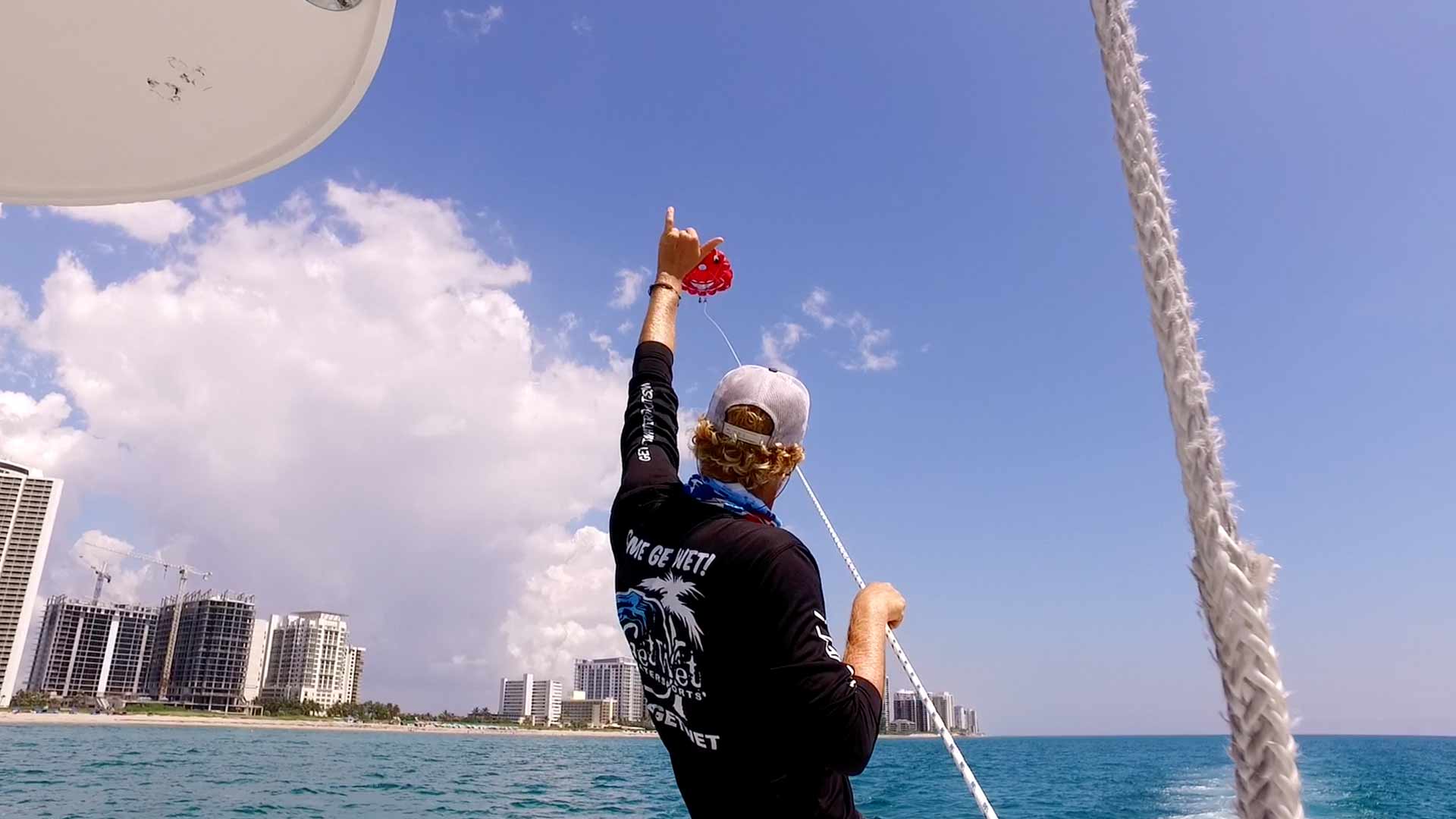 Boat captain giving cool sign to parasailers